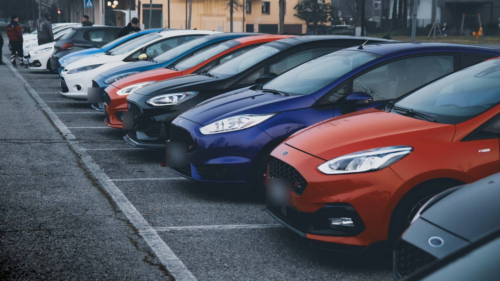 Pátio de loja de seminovos com carros hatch coloridos enfileirados